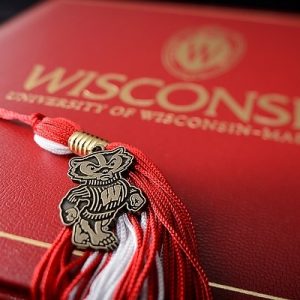 A graduation tassel with a pendant of mascot Bucky Badger is pictured with a University of Wisconsin-Madison diploma cover on May 1,