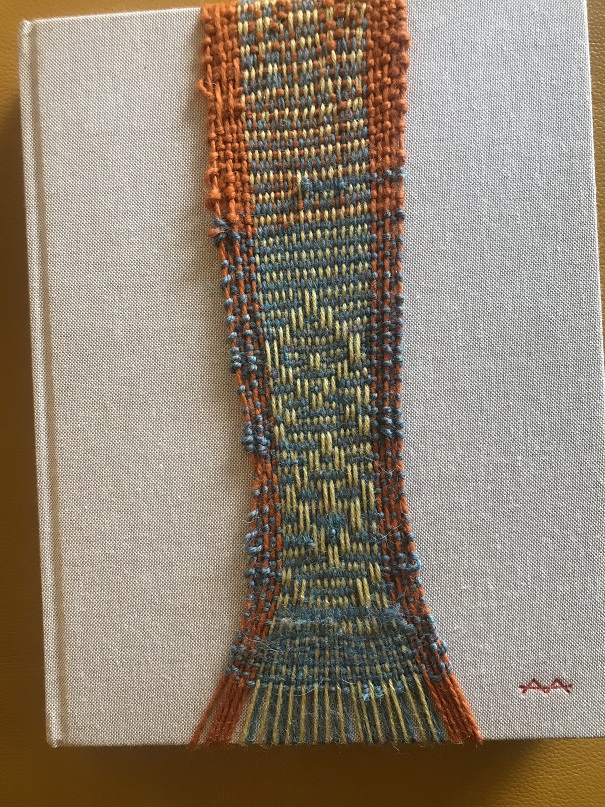 Orange, green, etc. weaving over gray book cover