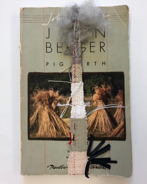 narrow tan, light green, white, and gray weaving with red detail over light green book cover