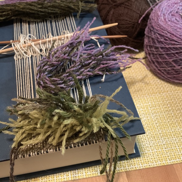 Kristen Wold 4 Book Weaving: purple, green, white, and brown weaving over blue hardcover Outlander