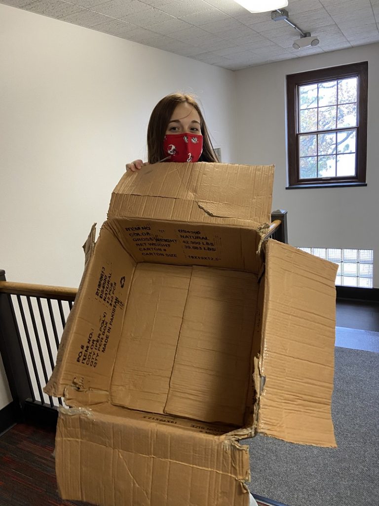 Done! Abby VanOoyen shows off an empty box after an afternoon's distribution event. Photo by Cassie Valle Alvarez.