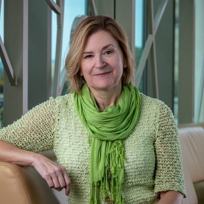 Professional photo of Linda Lepe in front of 100 Women Wall.