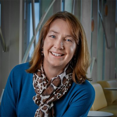 Professional photo of Lori Bakken in front of 100 Women Wall.
