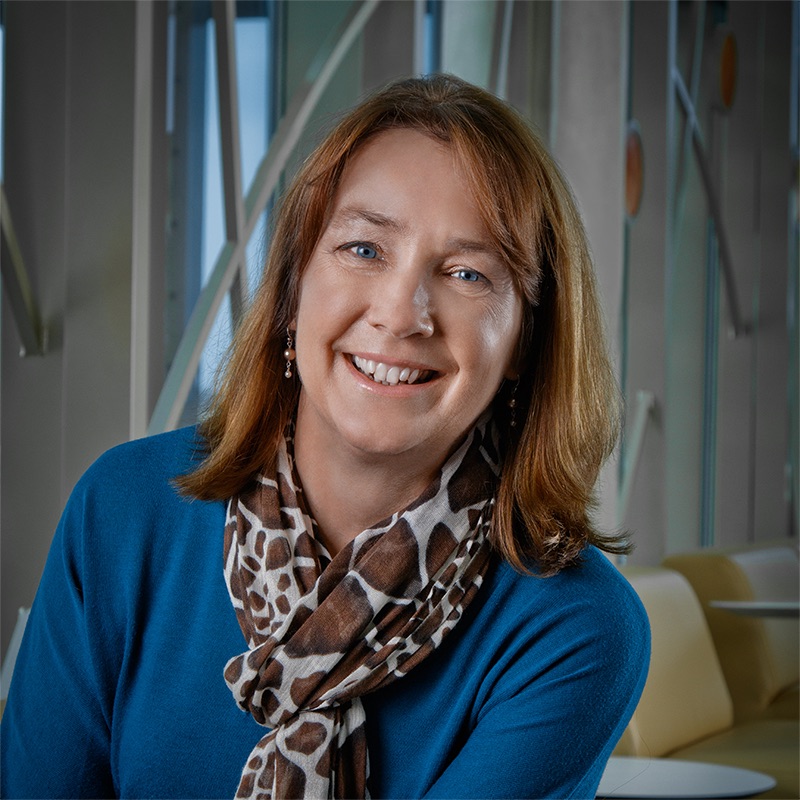 Professional photo of Lori Bakken in front of 100 Women Wall.
