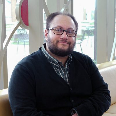 Professional photo of Michael Kukula in front of 100 Women Wall.