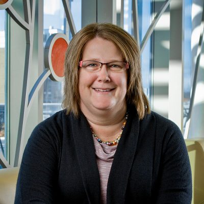 Professional photo of Tammy O'Brien in front of 100 Women Wall.