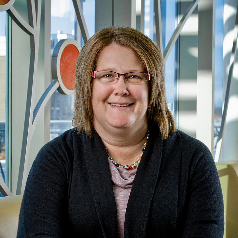Professional photo of Tammy O'Brien in front of 100 Women Wall.