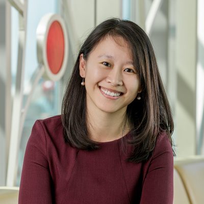 Portrait of Yiwei Zhang, an Asian woman smiling, with straight shoulder-length black hair, wearing a maroon dress.