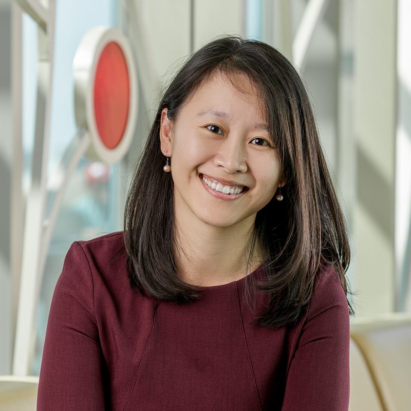 Portrait of Yiwei Zhang, an Asian woman smiling, with straight shoulder-length black hair, wearing a maroon dress.