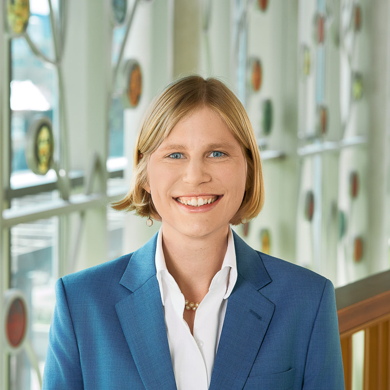 A white person smiling, wearing a blue suit jacket.