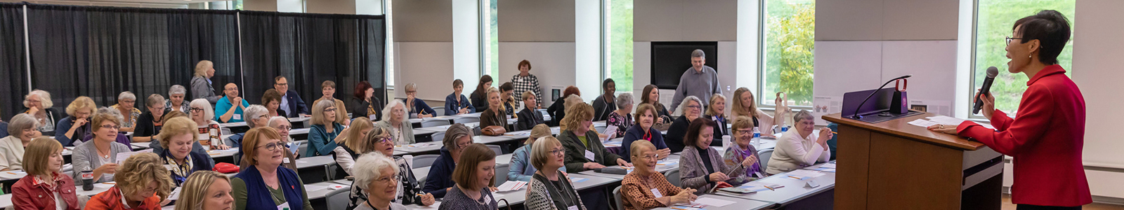 Dean Soyeon Shim stands at a podium in front of a large room of School of Human Ecology Alumni & Friends.