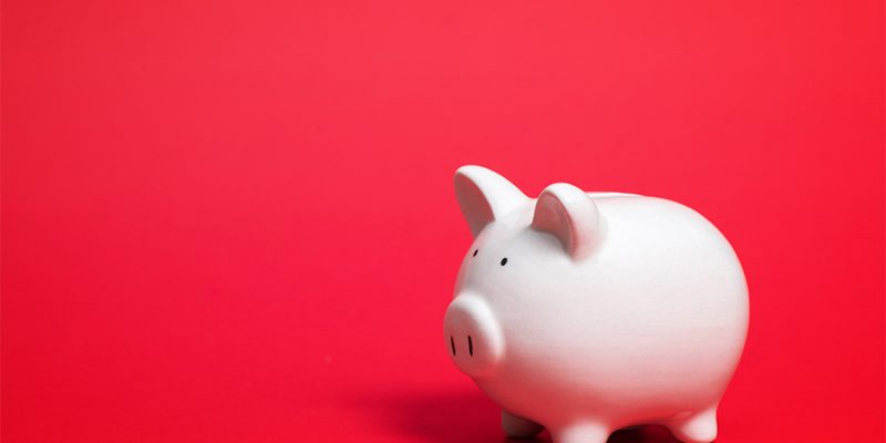 A piggy bank on a blank red background.