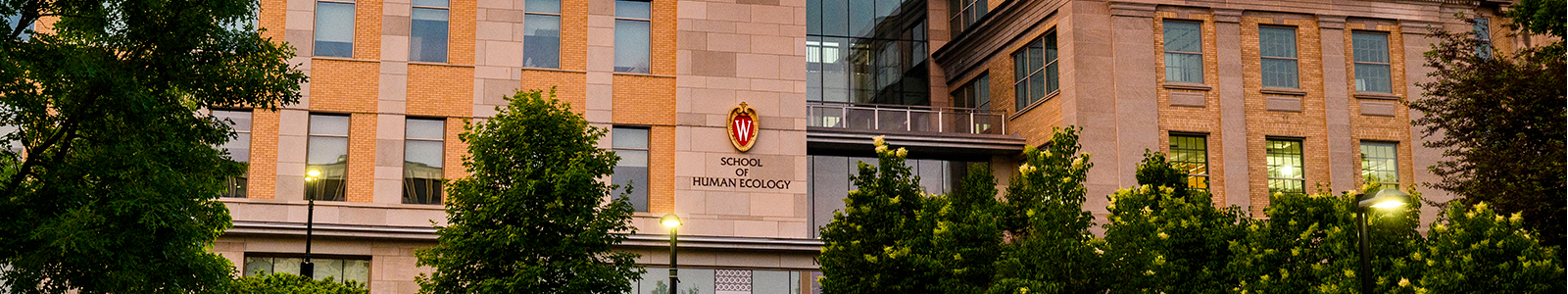 Exterior of Nancy Nicholas Hall in the evening, with lamps and windows glowing.