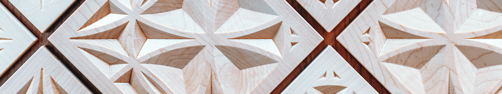 Close up of geometric shapes carved out of wood, from the wall inside Ember hall