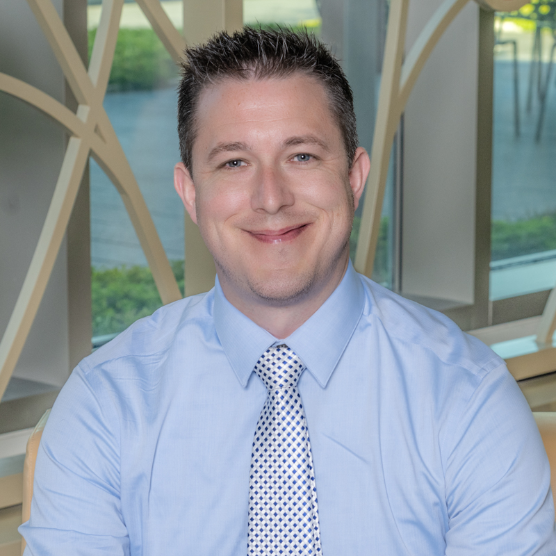Professional headshot of Cody Loew in front of 100 Women Wall.