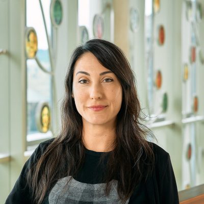 A light brown woman with long brown hair and brown eyes in black shirt.