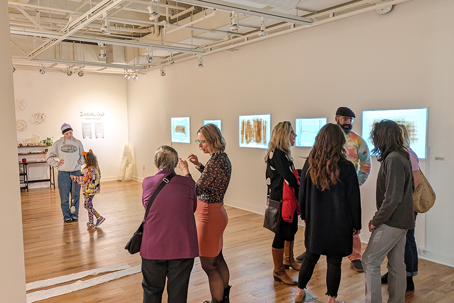 Three groups of people discuss amongst the artwork on the walls in the Ruth Davis Design Gallery.