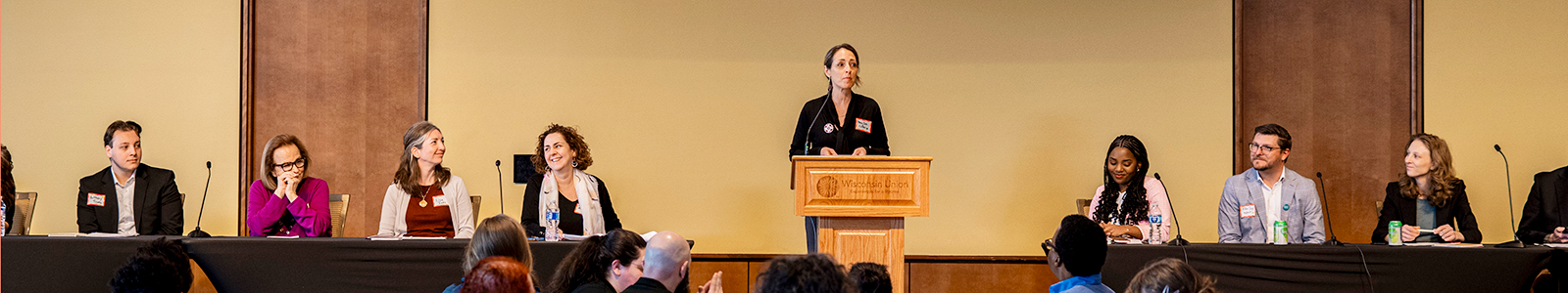 A person speaks at a podium to an audience
