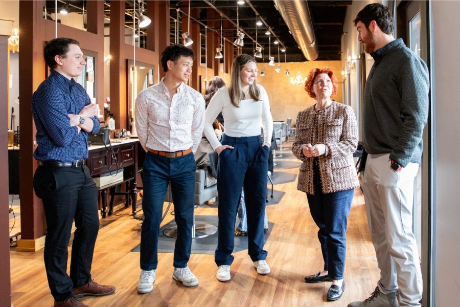 Four students talk with their business client on location at their salon.
