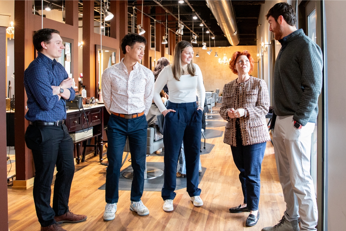 Four students talk with their business client on location at their salon.