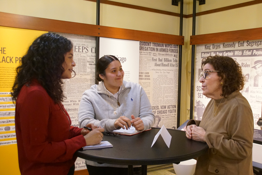 A group of three people networking around a table.