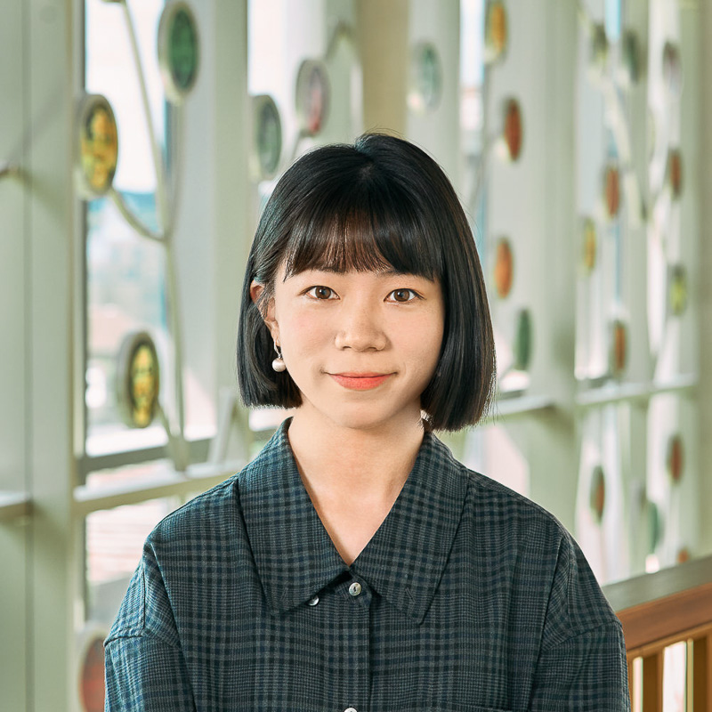 A Chinese woman，with black short hair and bangs，wearing a grey checked short.