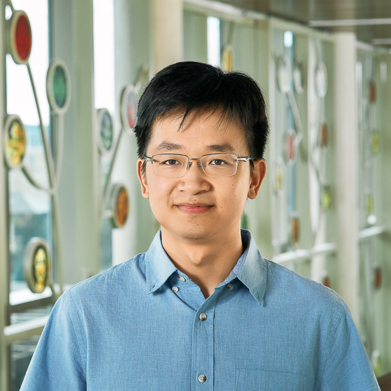A smiling person wearing a blue shirt.