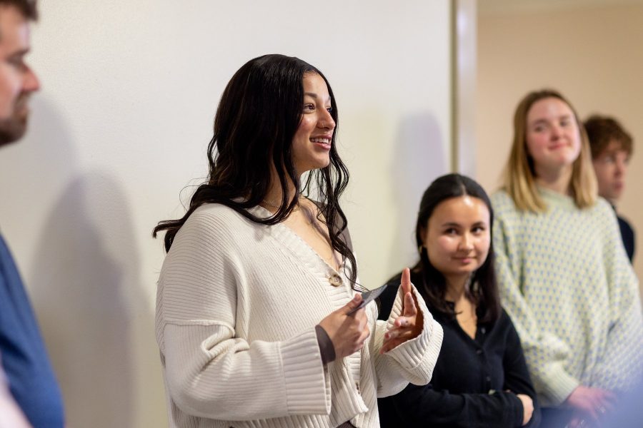 Design student speaks and gestures as fellow students listen