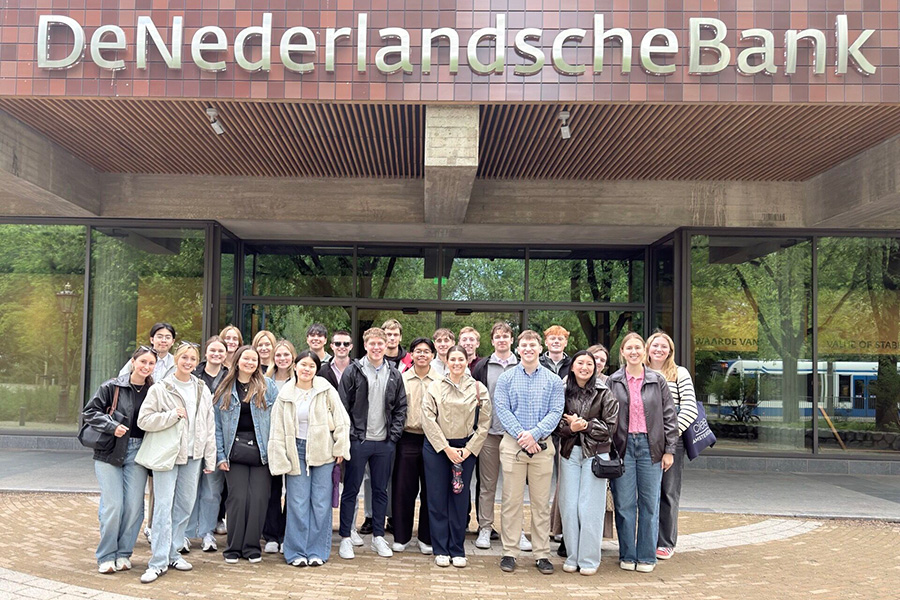 Group of students posing outside the De Nederlandsche Bank (Dutch Central Bank) in Amsterdam during a study abroad visit.
